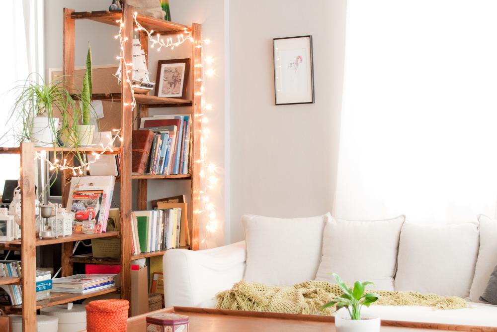 A bright living room with string lights on a wood shelf